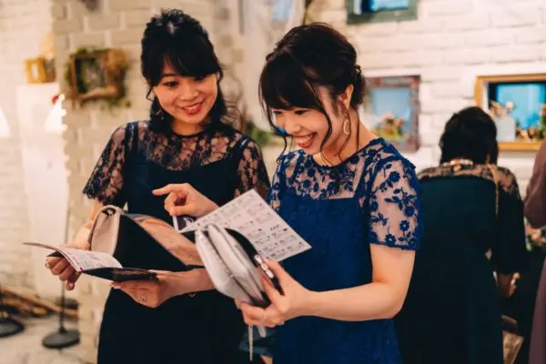 結婚式当日、配布アイテムを読むゲスト