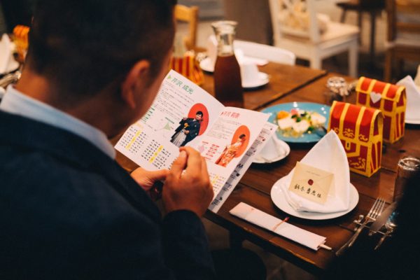 結婚式当日、テーブルで冊子を見るゲスト